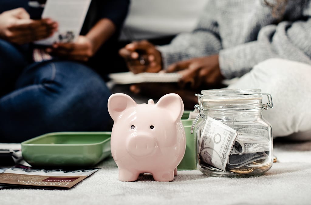 Piggy bank and jar of cash symbolizing family savings from selling a scrap car.