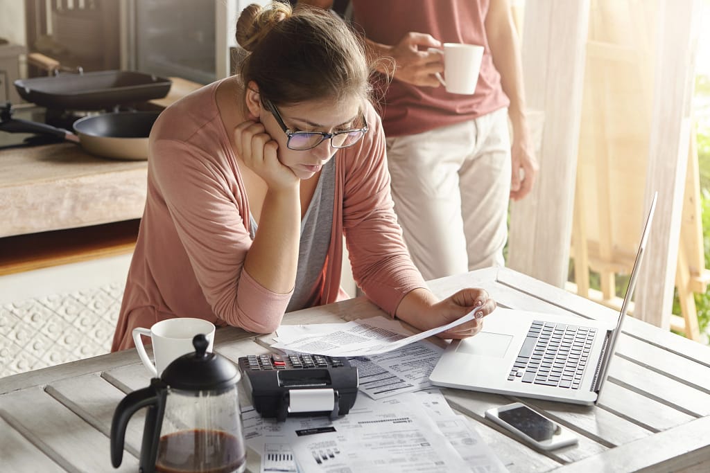 Woman reviewing family budget documents, highlighting savings from scrap car recycling.