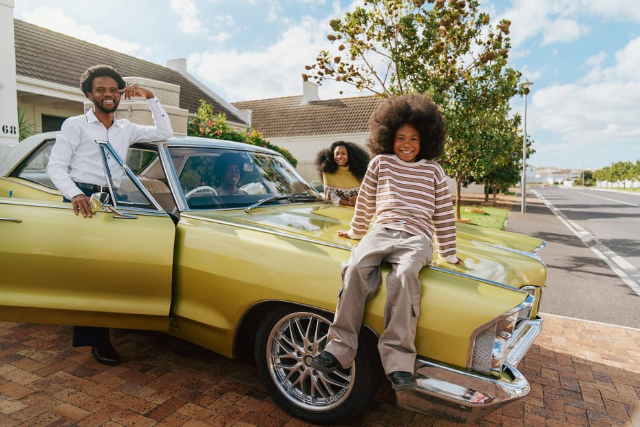 Family Smiling with Old Car, Highlighting Benefits of Scrapping for Parents